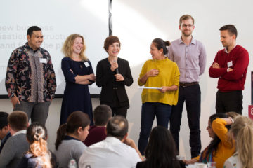 6 participants on stage presenting a final solution from the day long workshop.
