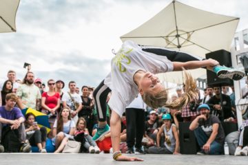 Person som dansar, publik i bakgrunden.