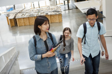 Three students walking in a building.