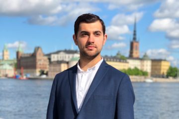 Portrait photo of a young man, with the Stockholm old town in the background.