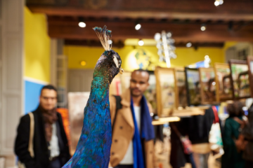 People looking at an artwork in the exhibition National Therapy at the Institut Suédois in Paris. Very colorful atmosphere mostly blue and yellow
