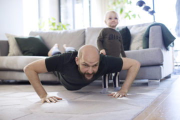 PhDad and child excercising at home on the living room rug