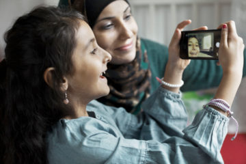 Två flickor tittar på en mobil