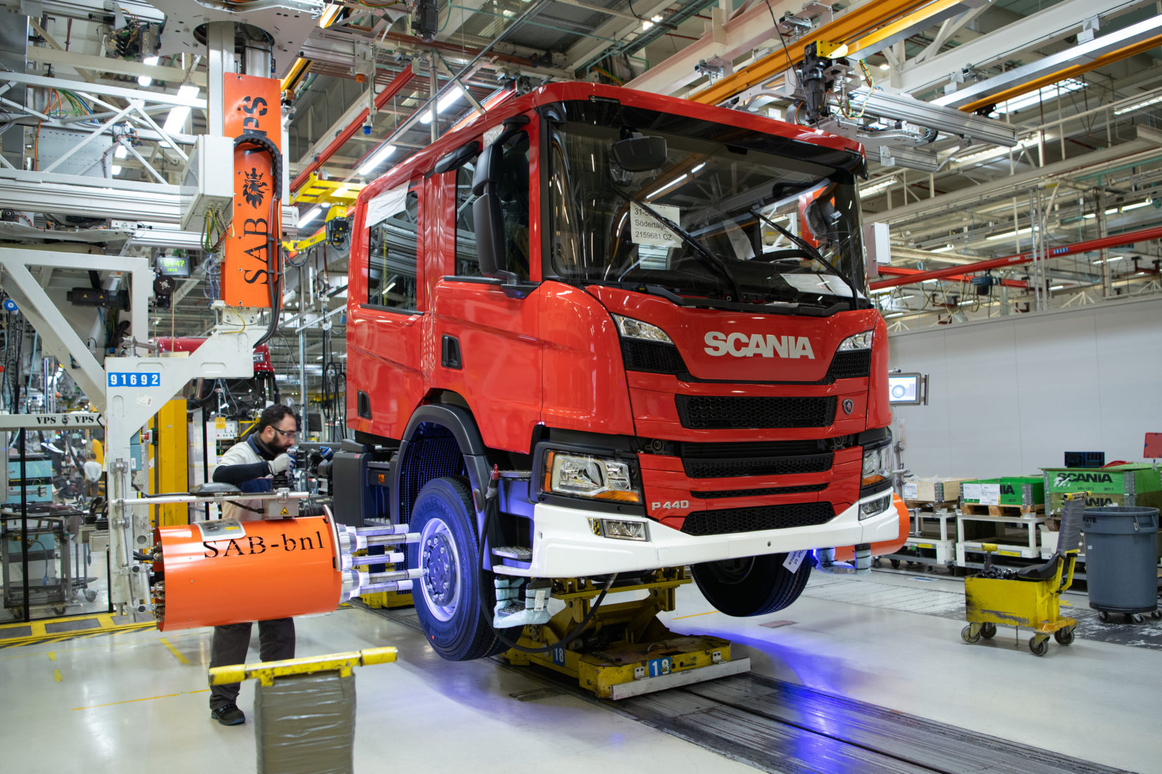 A man mounting wheel at Scania chassis assembly.