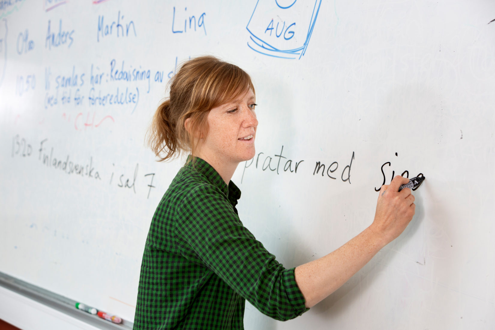 sofia_sabel-teacher-7157 Kvinnlig lärare står och skriver på en vit tavla