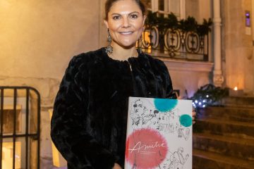 Kronprinsessan Victoria ler och håller boken Amitié i händerna..
