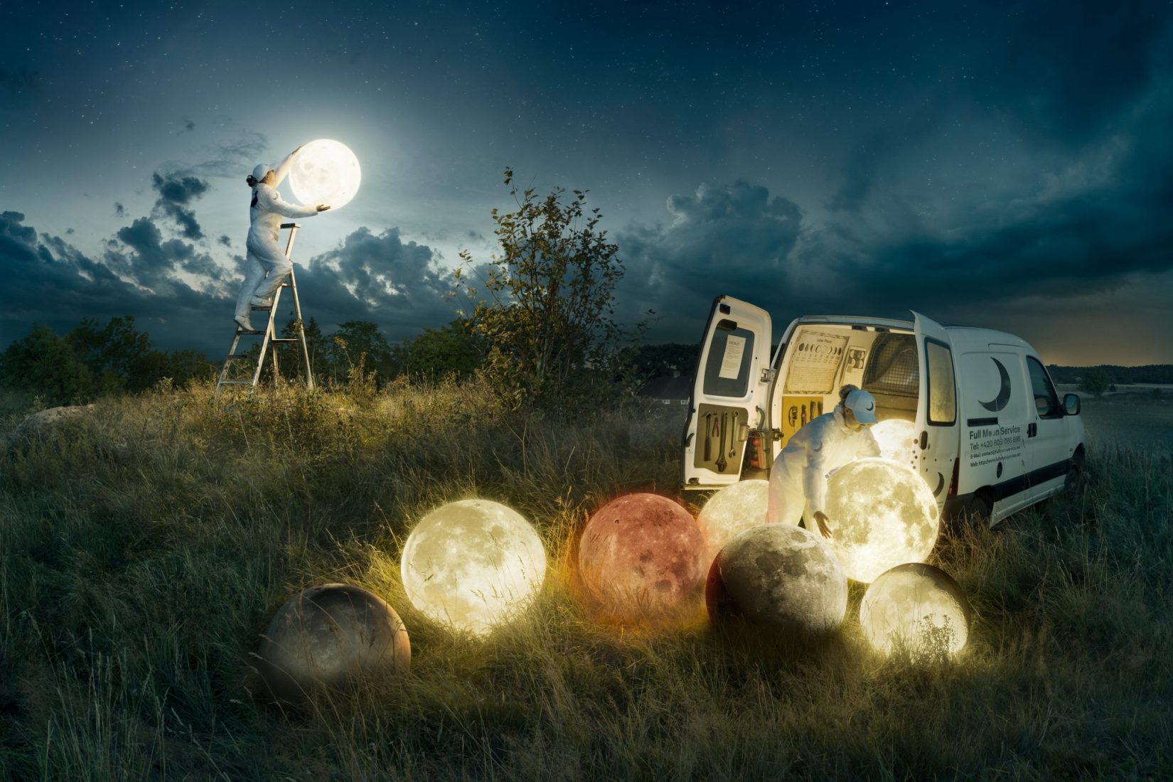 Verk med titeln: Full moon service. En man står på en stege och håller upp en rund lampa mot en natthimmel. På ängen framför honom ligger flera andra lysande lampklot. Som nedfallna månar.
