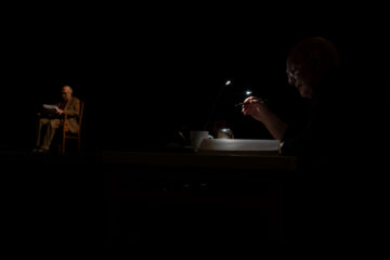 Lars Norén sitter vid ett skrivbord i ett mörkt rum