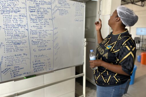 Woman (Ingrid) standing in front of an overview of todays mealplan