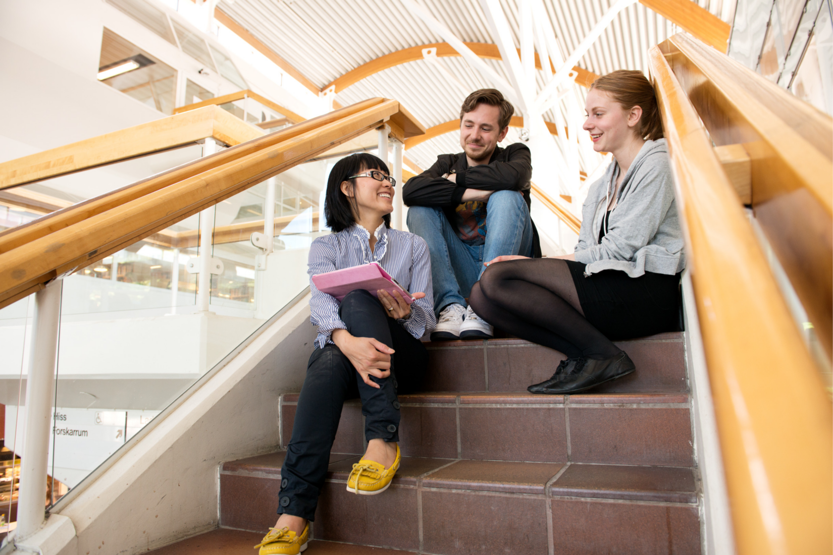 Dekorativ bild. Tre studenter sitter på en trappa.