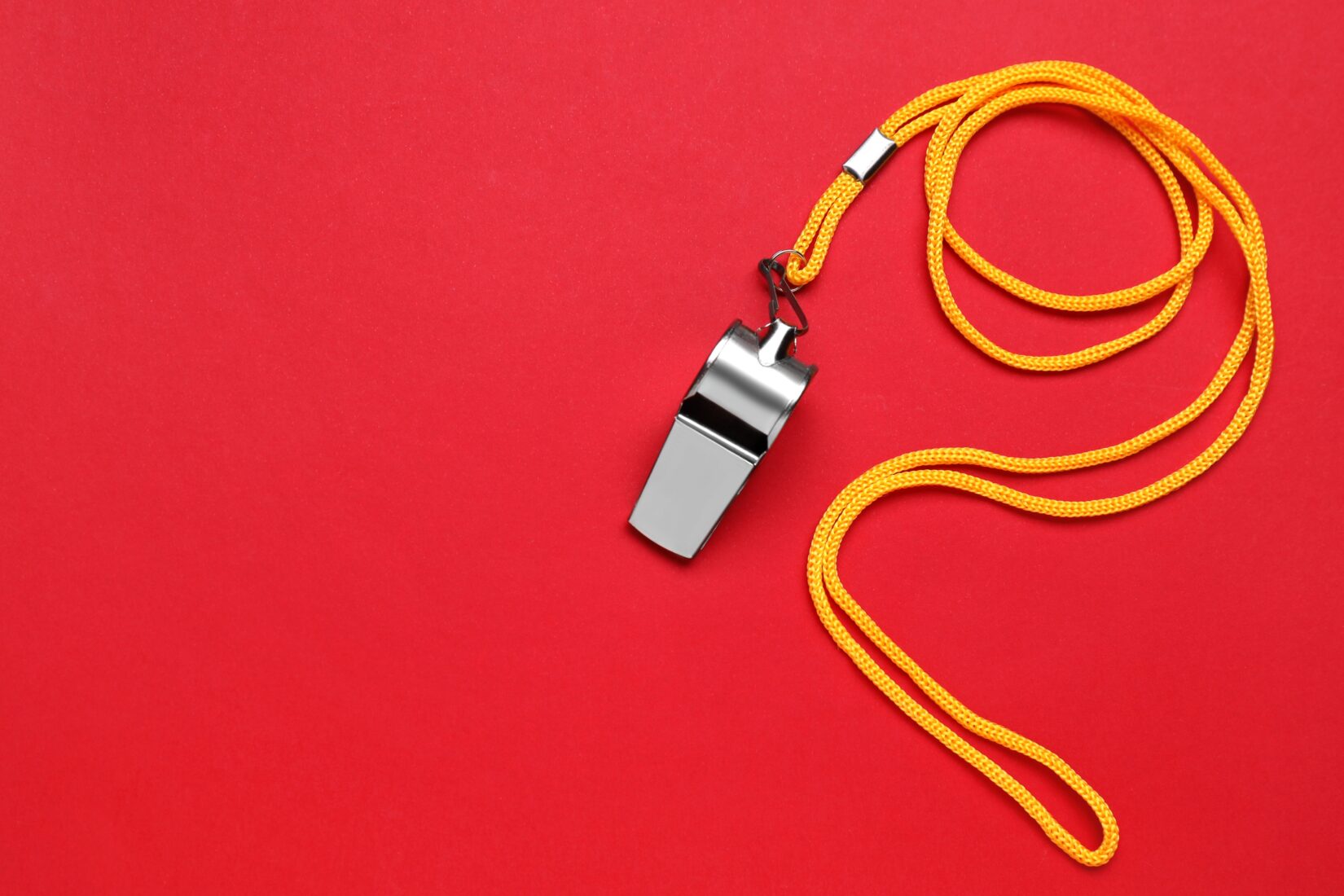 A silver whistle on a red background illustrates the Swedish institutes work in accordance with the whistleblower Act.