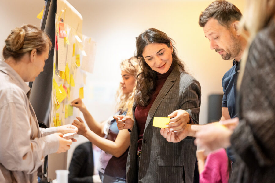 3 women and 1 man working with post its