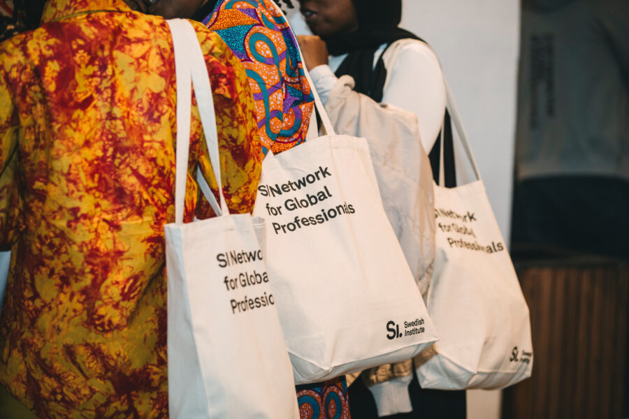 People carrying totebags with the Swedish Institute logo