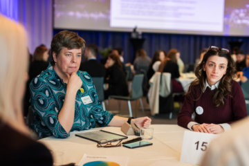 250508_DSC2782-3©Malin Nerby_SI Image of two conference participants sitting at around a table listening to the conference.