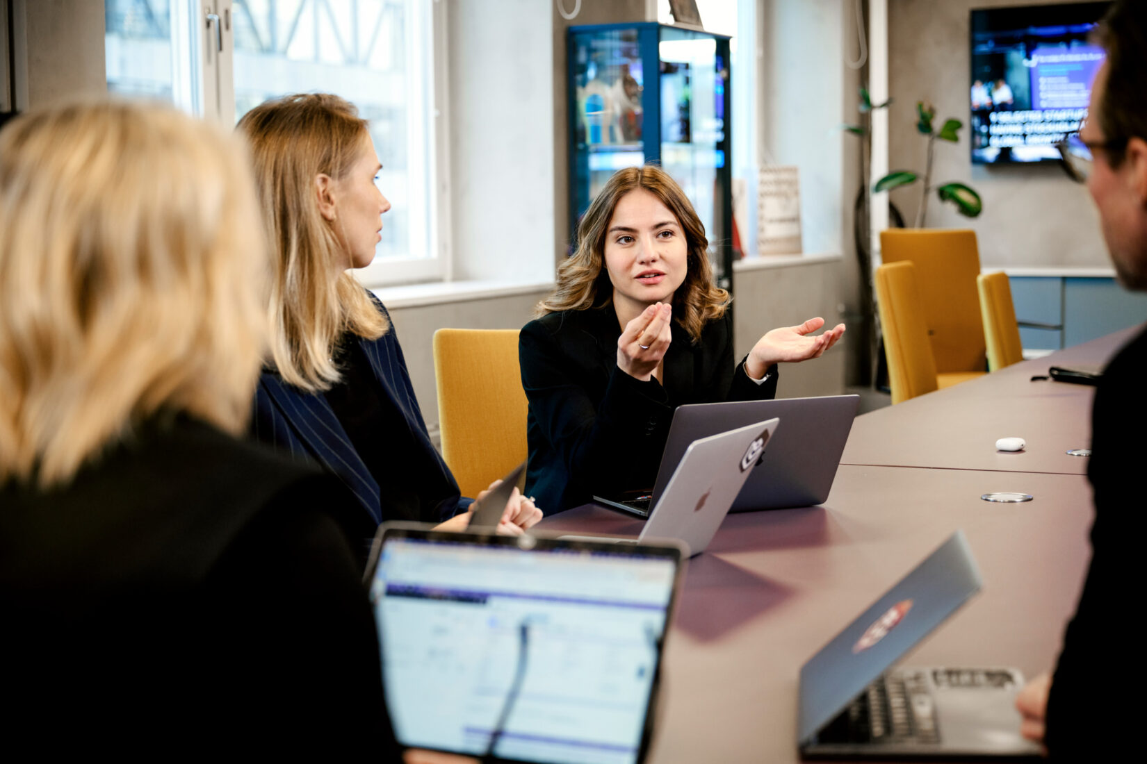 Fyra personer sitter runt ett bord och diskuterar.