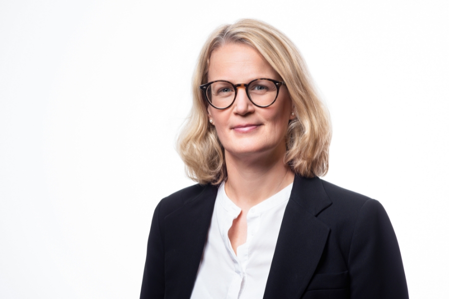 Kvinna i glasögon, ljus blus och mörk kavaj