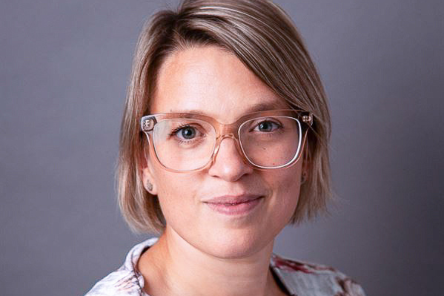 Kvinna med kort hår och glasögon i blommig blus