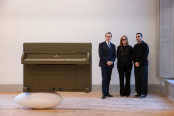 Foto på ett konstverk samt tre personer