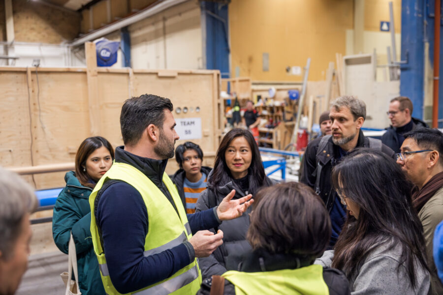 A man is standing in front of a group of people talking. 