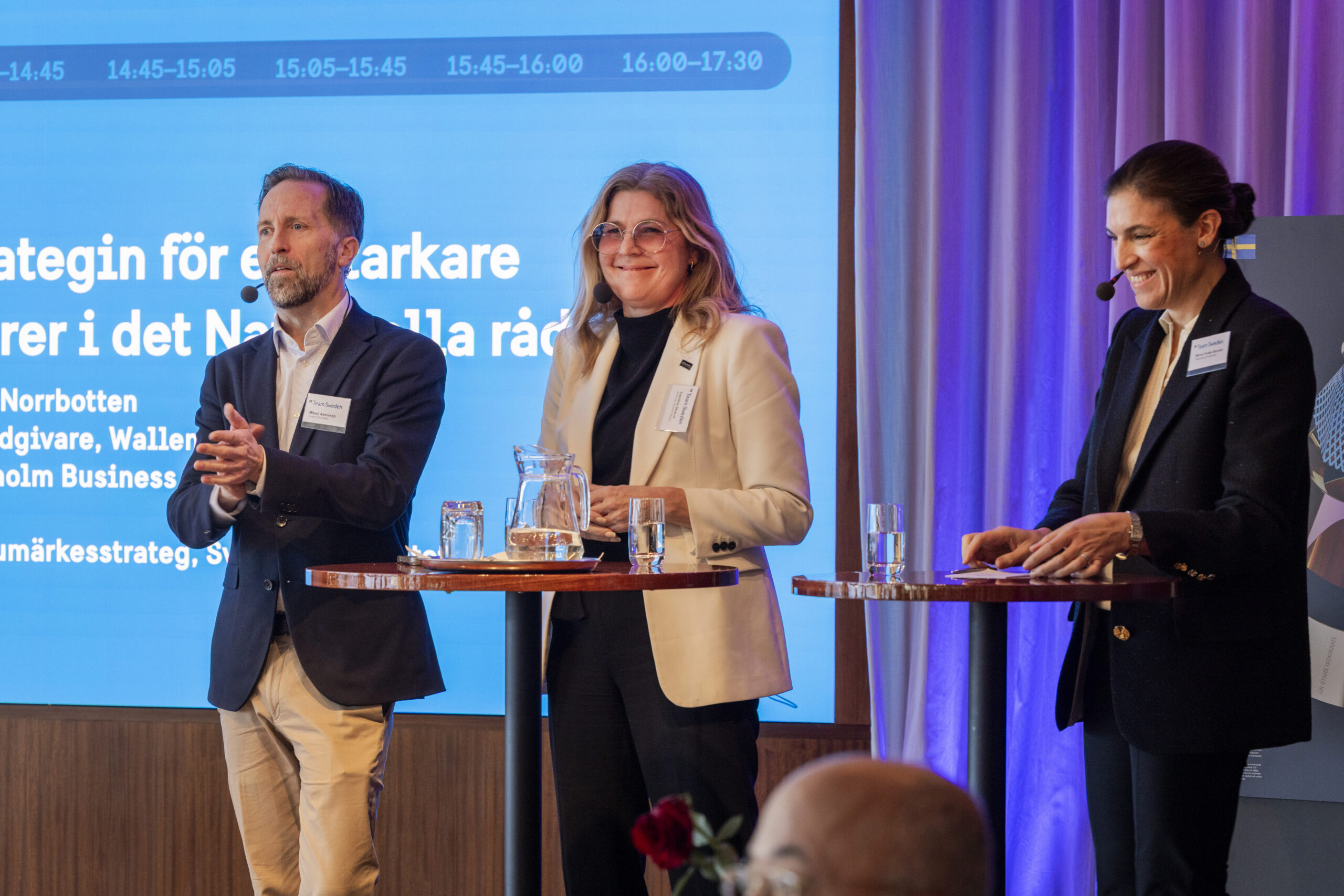 Paneldeltagare står på scen under ett samtal kopplat till varumärkesstrategin för en starkare Sverigebild i omvärlden, med en presentationsskärm i bakgrunden.