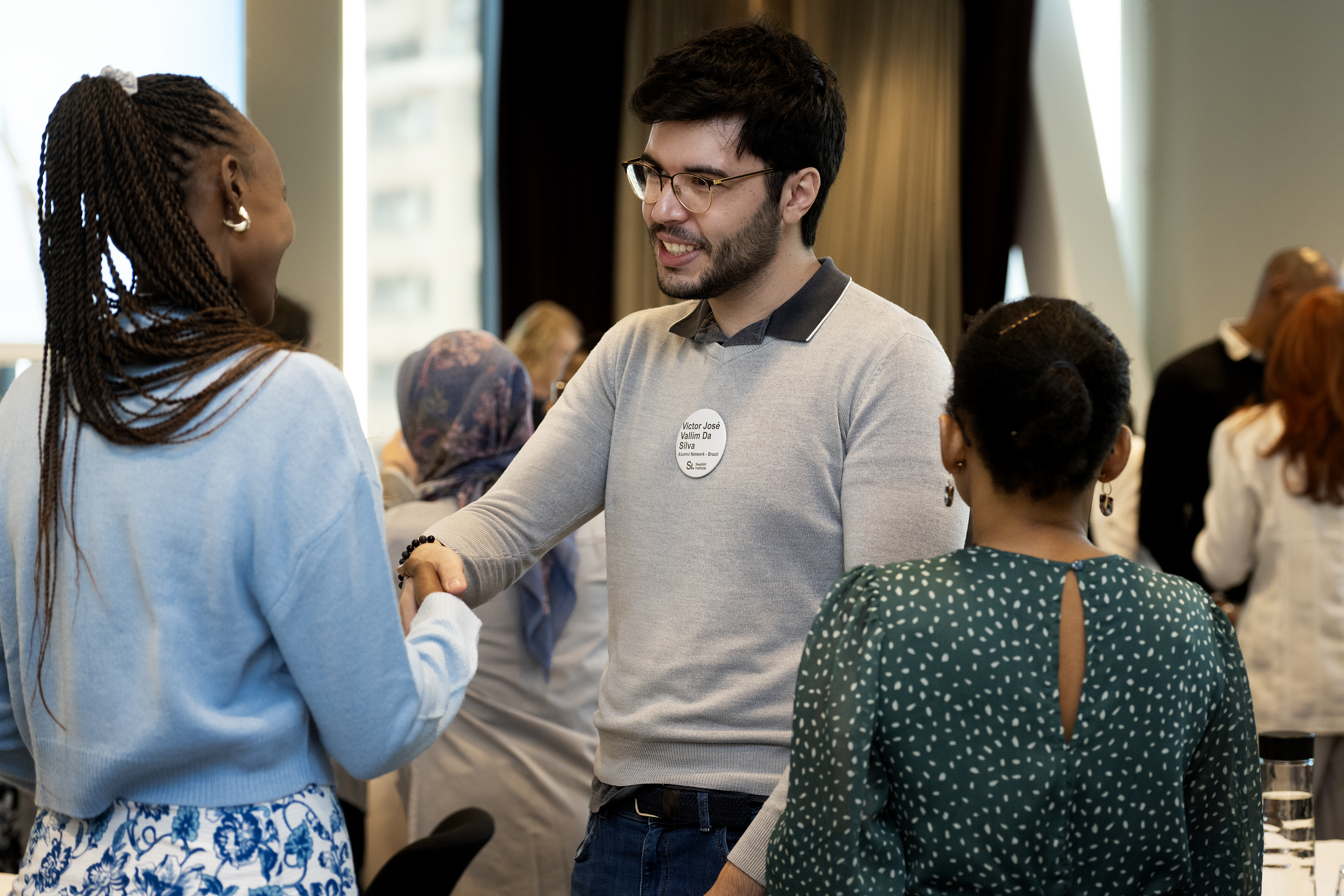 Deltagare i Svenska institutets globala alumnnätverk hälsar på varandra under ett möte, med fokus på dialog och internationellt kunskapsutbyte.